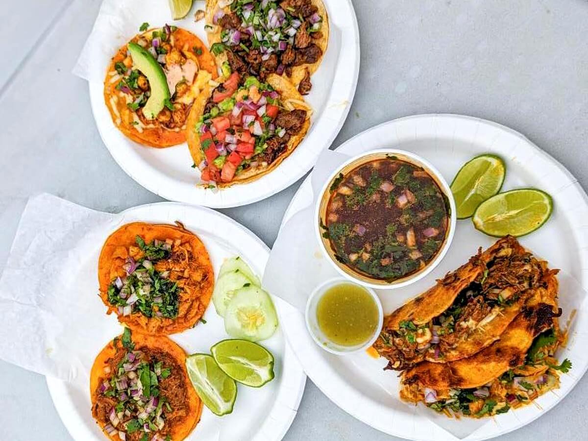Street tacos, crispy quesabirria, lime wedges and a bowl of consomé
